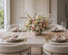Elegant dining table setting with floral centerpiece and place settings.