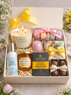 Gift box with candles, macarons, bath bombs, and other items on a floral background