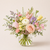 Bouquet of flowers in a clear vase on a light background