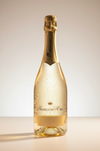 Prosecco bottle with gold cap and label on a light background